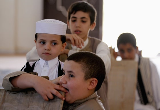 Image: Libyan boys are seen with wooden slates as they memorizes the holy Koran at a school in Benghazi