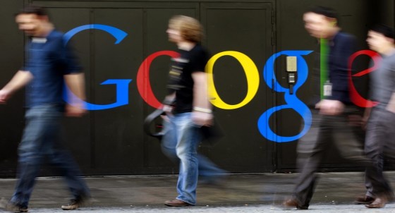 Image: Photo of people walking past a logo next to the main entrance of the Google building in Zurich