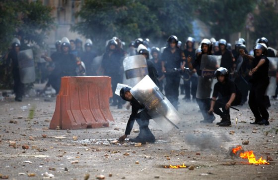 Image: Egyptian riot police throw stones at demonstrators during clashes close to the interior ministry in Cairo