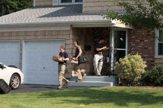 Image: Authorities remove packages from a house in Merrick, N.Y.