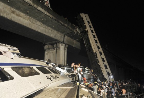 Image: mergency workers and people work to help passengers from the wreckage of train after two carriages from a high-speed train derailed