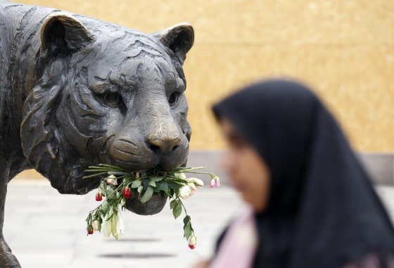 Image: Roses are placed on a statue near a temporary memorial site for the victims of the shooting spree and bomb attack in Oslo