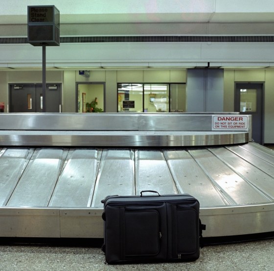 Image: Unattended suitcase sitting in baggage claim at airport