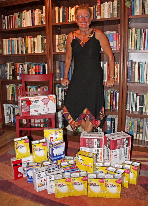 Image: Karen De Coster stands with her collection of traditional incandescent light bulbs.