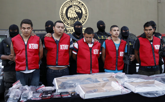 Image: State investigations agents escort five men arrested in connection with an attack on a casino during a presentation in Monterrey