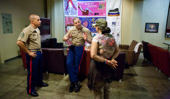 Master Sgt. Anthony Henry, center, and Staff Sgt. Chris Cano tell a prospective applicant she needs to lose weight.