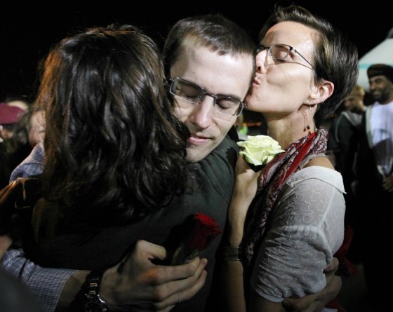 Image: Shane Bauer, one of the U.S. hikers who was held in Iran on charges of espionage, hugs fiance Sarah Shourd during his arrival in Muscat after his release from Tehran's Evin prison