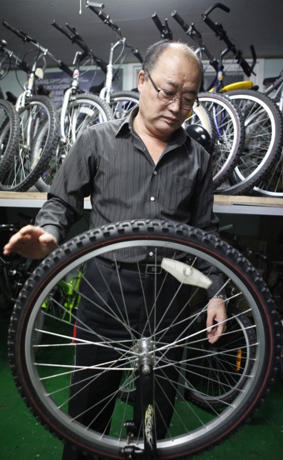 Image: Former spy Yoon Kyung-chul looks at an old bicycle at his office during an interview in Seoul