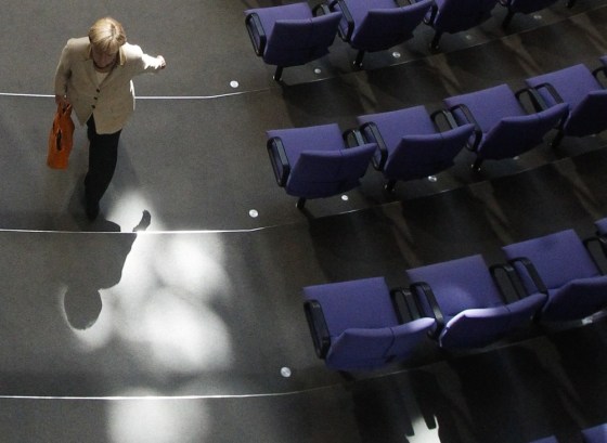 Image: German Chancellor Angela Merkel walks after voting at the session of the Bundestag lower house of parliament in Berlin