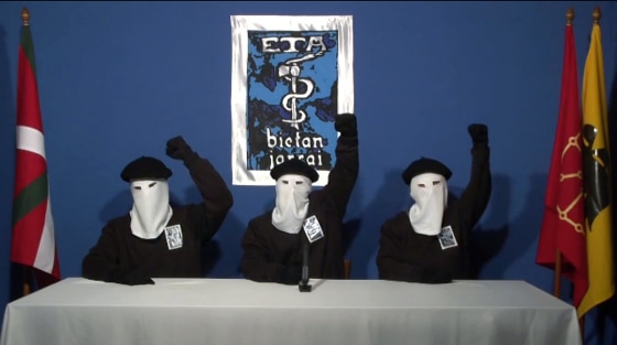 Image: hree ETA militants dressed in black shirts with white hoods over the heads
