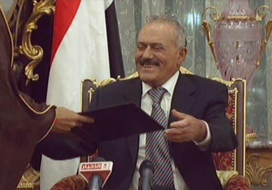 Image: Yemeni President Ali Abdullah Saleh smiling as he signs a Gulf Cooperation Council-sponsored transition deal to exit power
