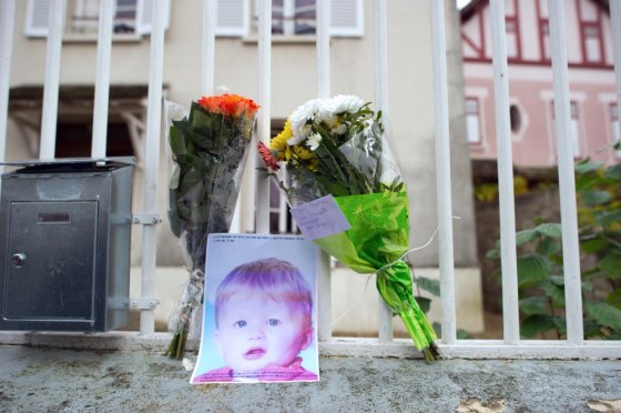 Image: Flowers and a picture of three-year-old child Bastien are seen at the entrance of the child's parents house.
