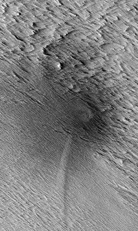 This HiRISE image from NASA's Mars Reconnaissance Orbiter shows a central crater on Mars with two dagger-like features extending at an angle. Called scimitars, these features most likely resulted from shockwave interference just before impact, scientists say.