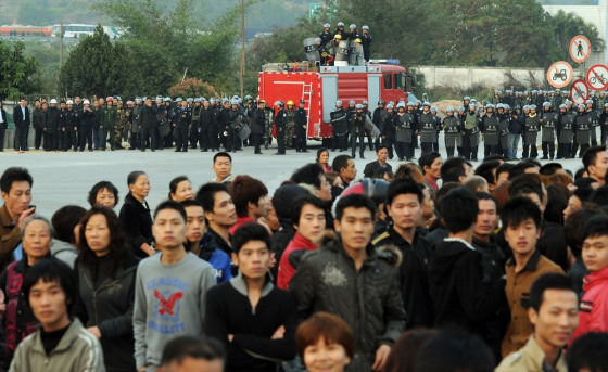 Image: Police block villagers after a large crowd formed at the scene of environmental protests over the past few days in the town of Haimen, Guangdong Province