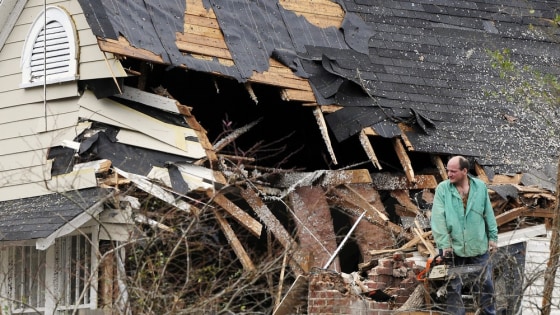 Image: Youngblood helps to clear a tree off a friend's house in Rome, Georgia after storms