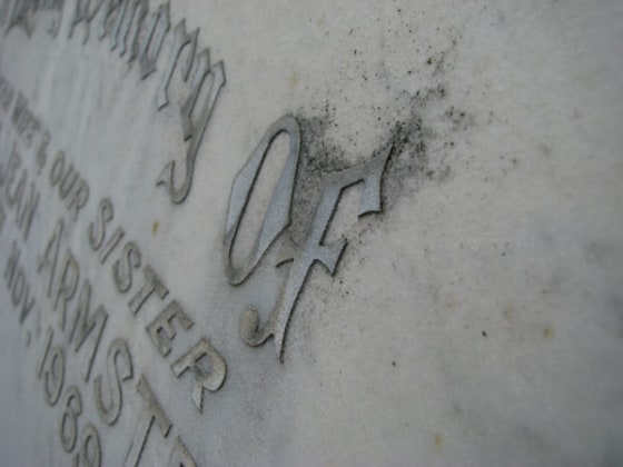 Lead lettering on a gravestone in Sydney, Australia. Volunteers measure the distance between the lettering and the stone to show how much the stone has weathered since it was put into the ground.