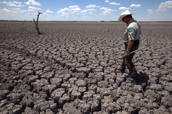 Image: Texas State Park police officer Thomas Bigham walks across the cracked lake bed of O.C. Fisher Lake