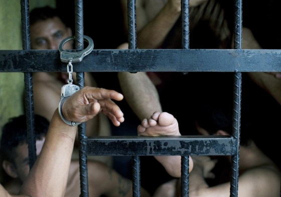 Image: An inmate's wrist is handcuffed to the cell bars as punishment for beating a guard