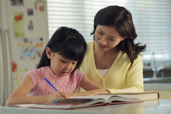 Image: A mother helps her daughter with homework