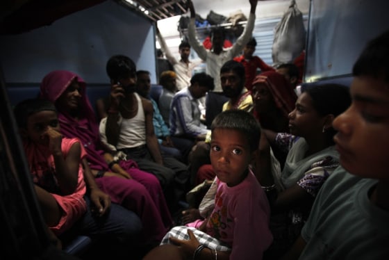 Image: Passengers sit in a train and wait for power to get restored at a railway station in New Delhi, India.