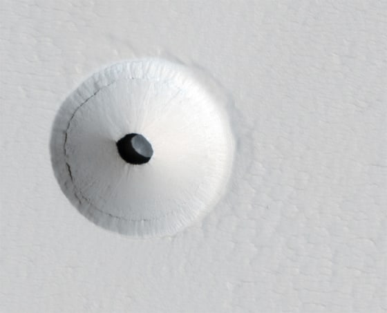 A skylight opens into an underground cavern on the slopes of Mars' Pavonis Mons volcano, as observed by NASA's Mars Reconnaissance Orbiter.