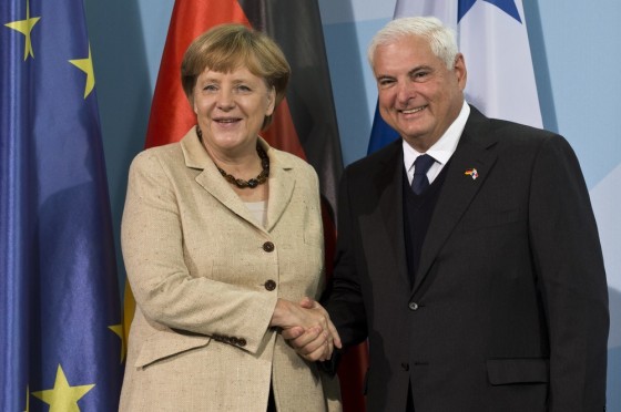Image: German Chancellor Angela Merkel (L) and Panama's President Ricardo Martinelli shake hands.
