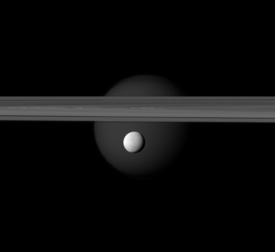 Image:Saturn’s Enceladus hangs below the gas giant’s rings while Titan lurks in the background.