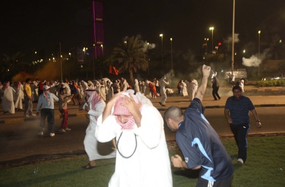 Image: Protesters run from tear gas during a demonstration against proposed changes to election laws in Kuwait City