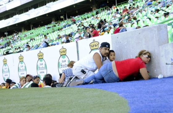 Image: Fans of Santos and Morelia react during the Mexican league championship soccer match after gunshots were heard in Torreon