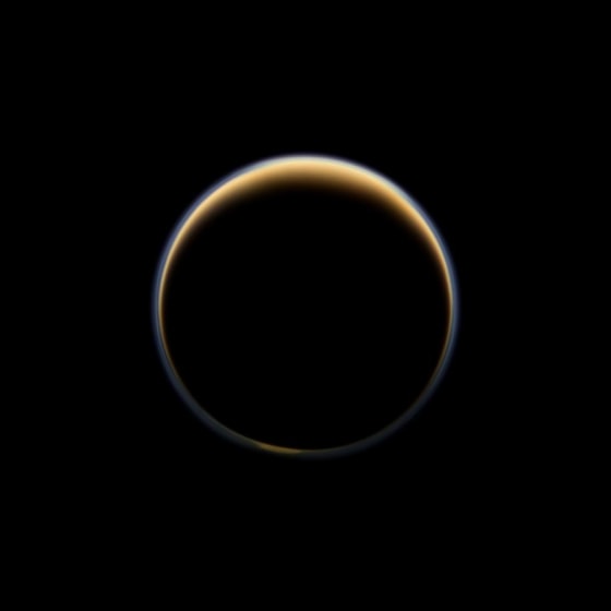 This night-side photo of Titan taken by the Cassini spacecraft shows a buildup of haze over the Saturn moon's south pole (bottom). New results from Cassini's infrared spectrometer show that air is now sinking at the south pole, leading to increased temperatures at high altitude and a large enrichment in trace gases.