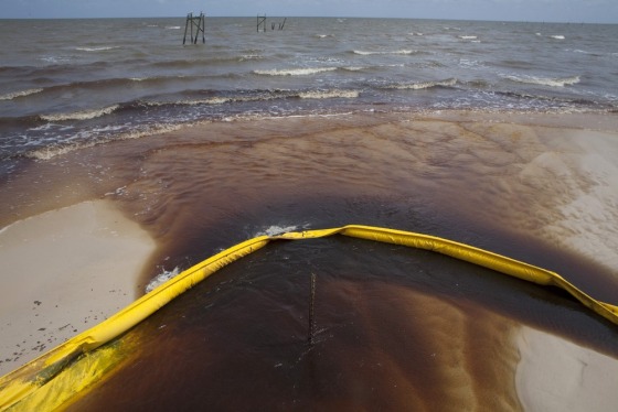 Image: File photograph of a protective boom as oil from the Deepwater Horizon spill recedes back into the Gulf of Mexico after washing into a drainage canal in Waveland