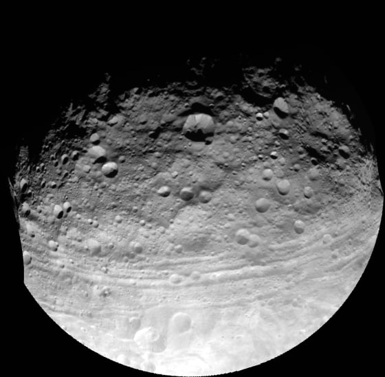 An image taken by NASA's Dawn spacecraft on July 24, 2011, shows troughs along the equator of the asteroid Vesta, including Divalia Fossa, which is larger than the Grand Canyon. A new study analyzing these troughs finds that they are probably graben – a dip in the surface with faults on either side that would indicate that Vesta has characteristics much like a planet 