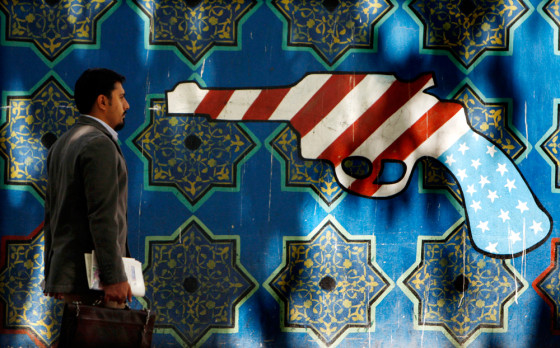 Image: An Iranian man walks pass an anti-U.S. graffiti