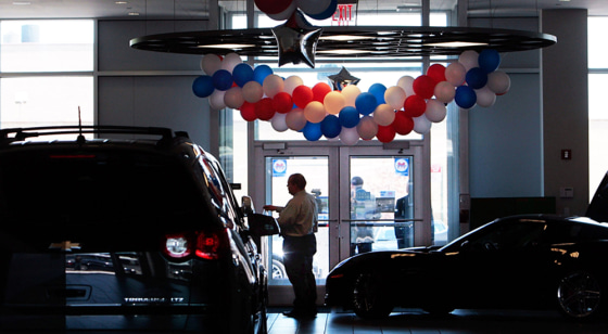 Image: A man stands in the showroom of the Chevrolet-Saturn dealership in New York City in June.