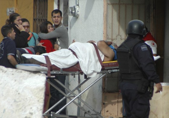 Image: Man is taken away by paramedics after unknown gunmen opened fire killing at least one person in Juarez, Mexico