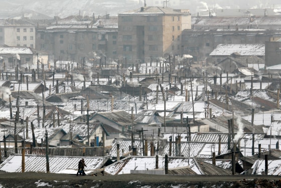 Image: North Korean walk on the banks of the Yalu river at the border with China near the North Korean city of Hyesan