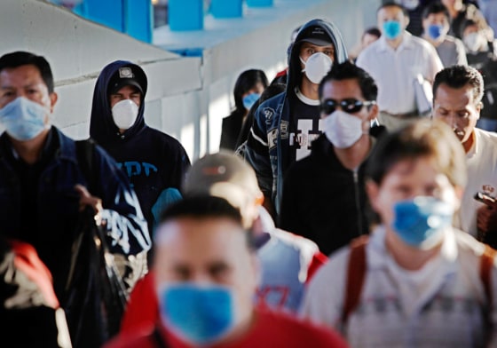 Image: Passengers wearing face masks as a precaution against swine flu walk inside a metro station in Mexico City