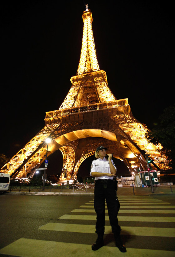 Image: A police officer stands front the Eiffel Tower