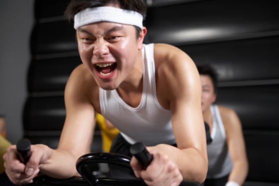 Image: man on stationary bike at gym