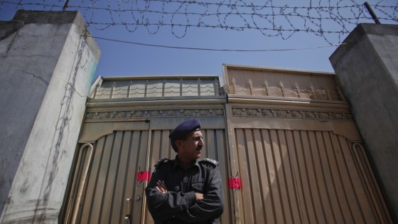 Image: A policeman stands guard outside one of two gates of the compound where al Qaeda leader Osama bin Laden was killed in Abbottabad
