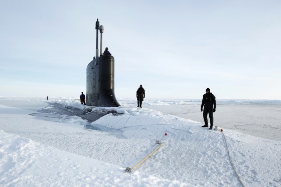 Image: U.S. Navy safety swimmers stand on the deck of the Virginia class submarine USS New Hampshire after it surfaced in the Arctic Ocean north of Prudhoe Bay