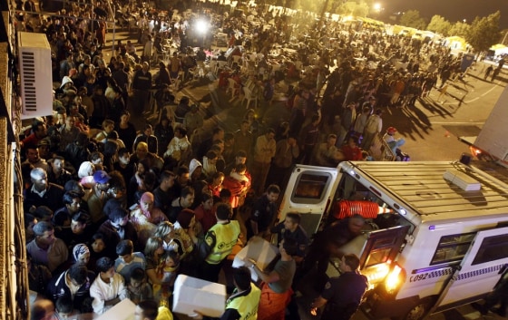 Image:Ambulance workers tend to needy people who are spending the night outside their homes in Lorca, Spain, in the early hours of Thursday.