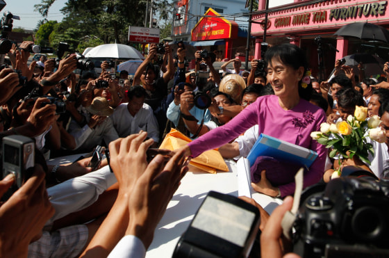Image: Myanmar democracy leader Aung San Suu Kyi shakes hands with people outside the National League for Democracy (NLD) head office after a meeting in Yangon