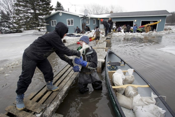 Karen Thoreson and Clarence Sitter help arrange sandbags around a house which borders the flooding Red River in Fargo