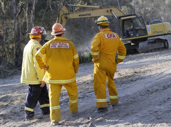 Firefighters watch an excavator prepare a firebreak inside Lysterfield State Park near Melbourne, Australia, on Thursday.