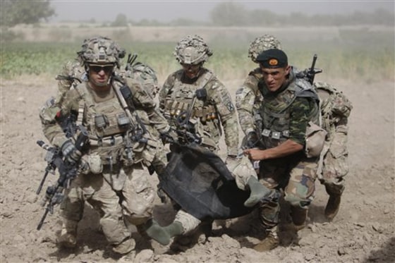 An Afghan National Army soldier along with U.S soldiers carry a wounded U.S soldier following an attack to a medevac helicopter near Kandahar on Saturday. 