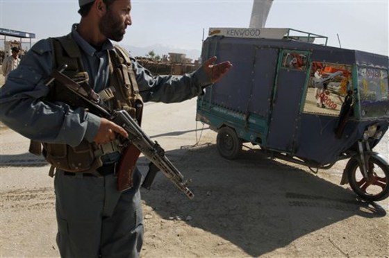 An Afghan policeman stops a three-wheeler near the U.S. air base in Bagram, Afghanistan, Wednesday. Insurgents launched a brazen pre-dawn assault Wednesday against the giant U.S.-run Bagram Air Field, killing an American contractor and wounding nine service members in the second Taliban strike at NATO forces in and around the capital in as many days.