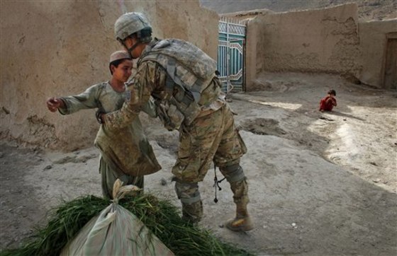 A United States soldier from Bravo Company, 2nd Battalion of the 508 Parachute Infantry Regiment of the 82nd Airborne, searches a young Afghan boy during a patrol in the village of Pir-e-Paymal in the volatile Arghandab Valley, outside Kandahar City, on Wednesday.