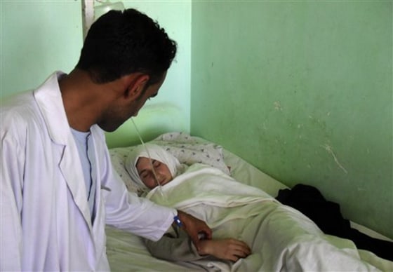 A medic at the hospital in Kunduz, Afghanistan, checks on one of the hospitalized schoolgirls.