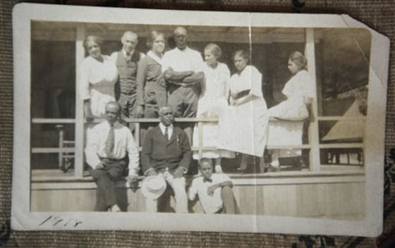 In this 1918 photo provided by Lee Jackson Van Allen, singer composer, and soloist singer Harry T. Burleigh, holding hat, below second from left, and Charles H. Shearer, top row second from left, founder of Shearer Cottage, who was born a slave in 1854, appear with family and friends at the inn in Oak Bluffs, on the island of Martha's Vineyard, Mass.